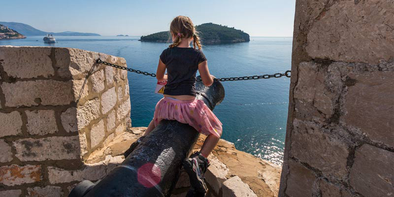 Kid climbing a canon on Dubrovnik city walls 