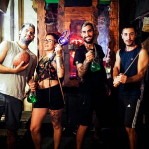 Travellers in a Game of thrones inspired escape room holding wildfire, dragon egg and sword.